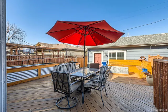 a view of a swimming pool with a table and chairs under an umbrella