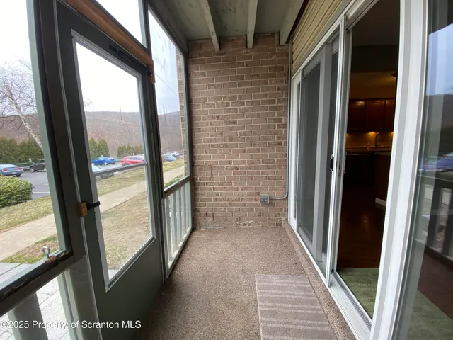 a view of hallway with wooden floor and door