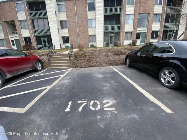 a front view of a building with parking space