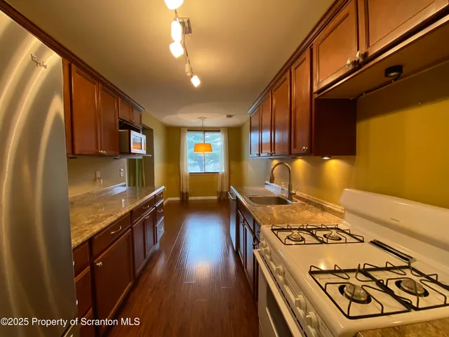 a kitchen with a stove and a wooden floors