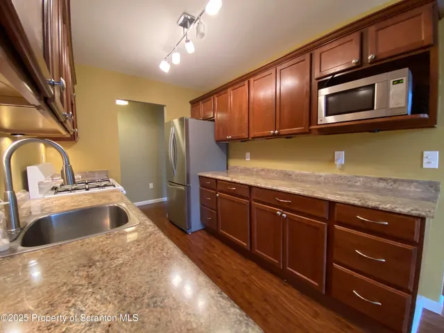 a kitchen with stainless steel appliances granite countertop a sink and a microwave
