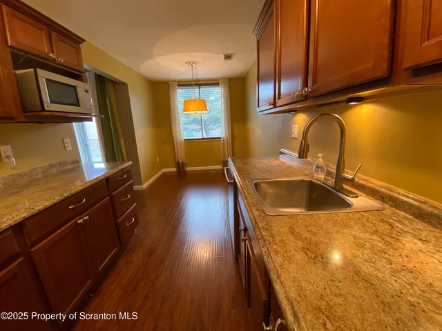 a kitchen with stainless steel appliances granite countertop a sink a stove counter space and cabinets