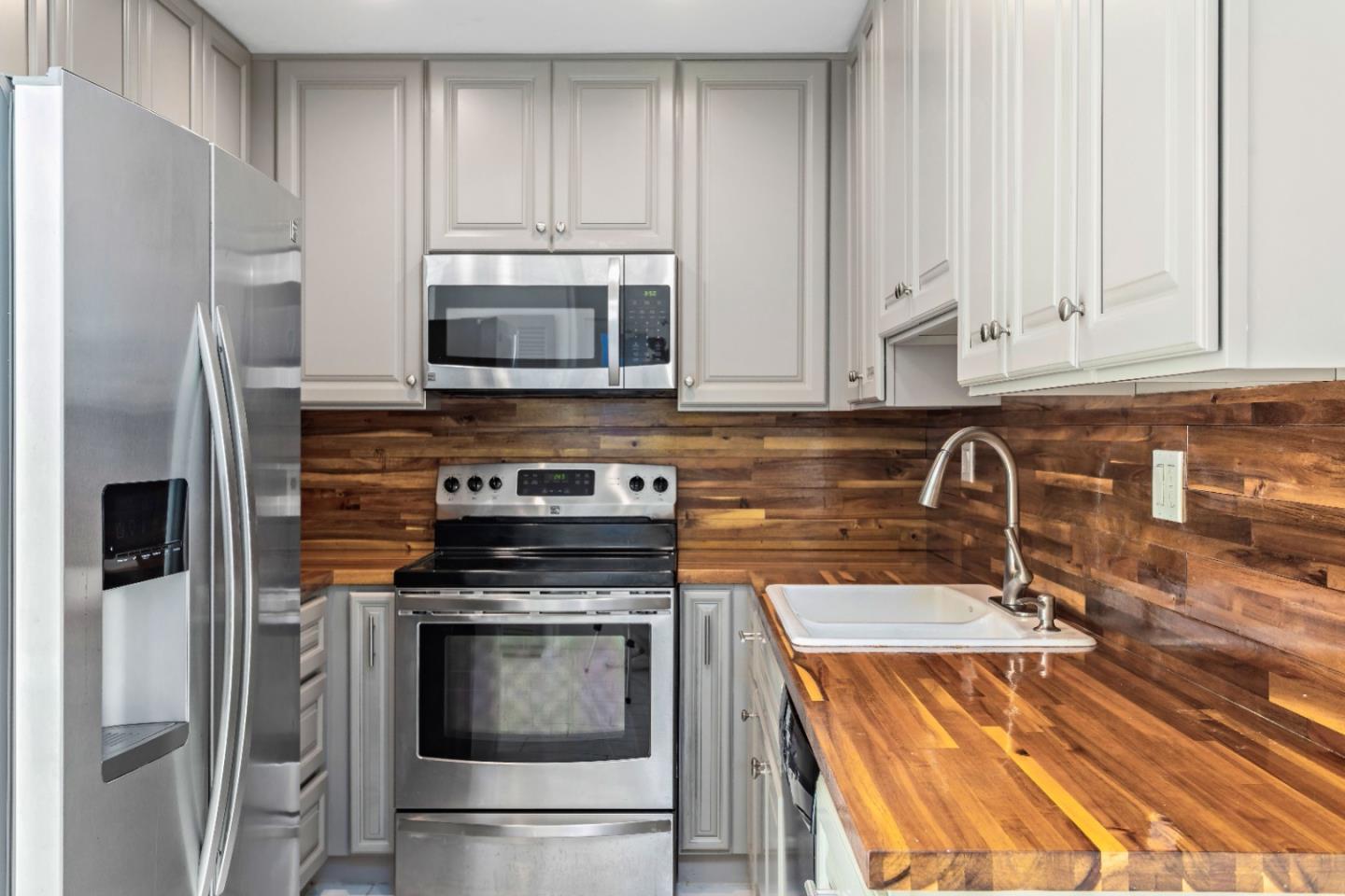 5510 Armitos Avenue, Unit 4 Goleta, CA 93117 - Photo 15 of 23 a kitchen with stainless steel appliances granite countertop a stove a microwave and a refrigerator