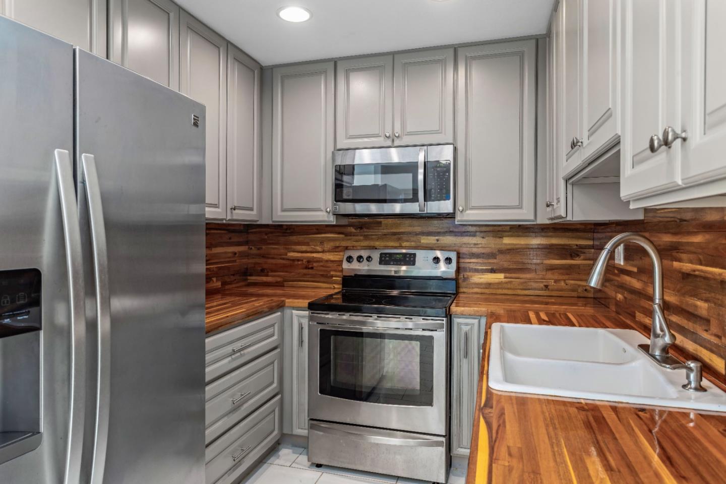 5510 Armitos Avenue, Unit 4 Goleta, CA 93117 - Photo 2 of 23 a kitchen with stainless steel appliances granite countertop a refrigerator a stove and a sink with wooden cabinets