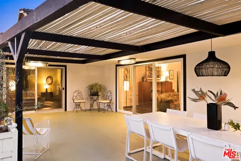 a dining room with furniture and large windows