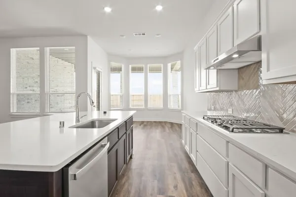 a kitchen with granite countertop a sink stove and cabinets
