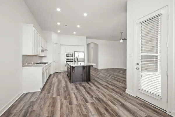 a view of an empty room with window and wooden floor