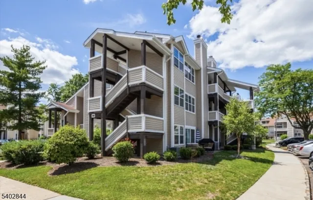 a view of a white building among the yard and large trees