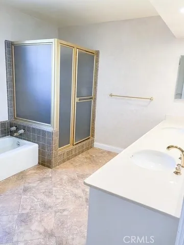 a spacious bathroom with a tub sink and a mirror