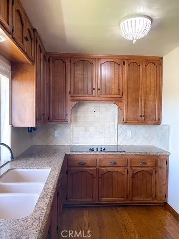 a kitchen with kitchen island granite countertop wooden cabinets a sink and dishwasher