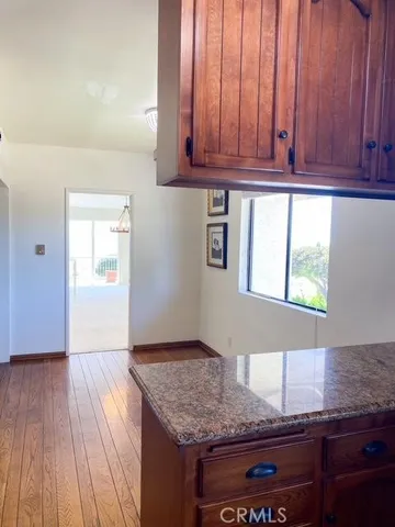 a kitchen with granite countertop wooden cabinets a sink and dishwasher