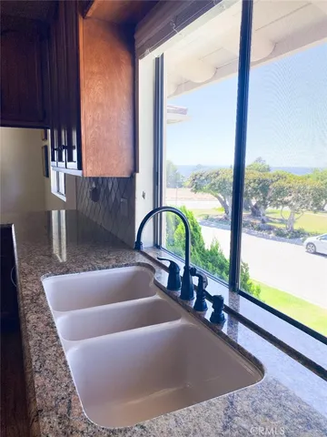 a view of a living room with a floor to ceiling window and wooden floor