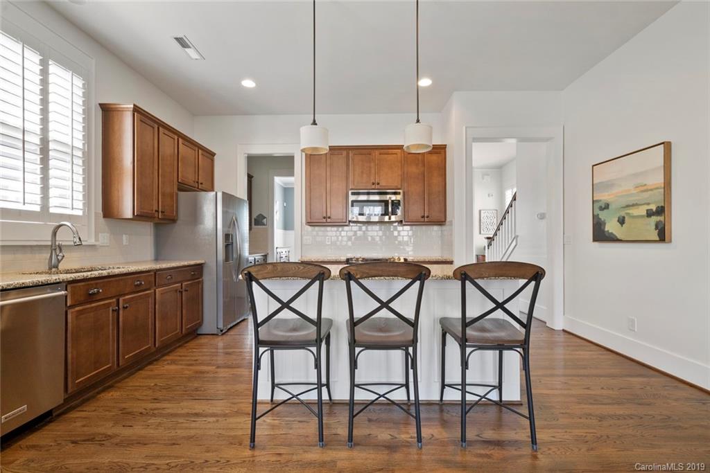 436 Hollyhock Lane Fort Mill, SC 29708 - Photo 14 of 34 a kitchen with stainless steel appliances kitchen island granite countertop a kitchen island a chair a sink and a refrigerator