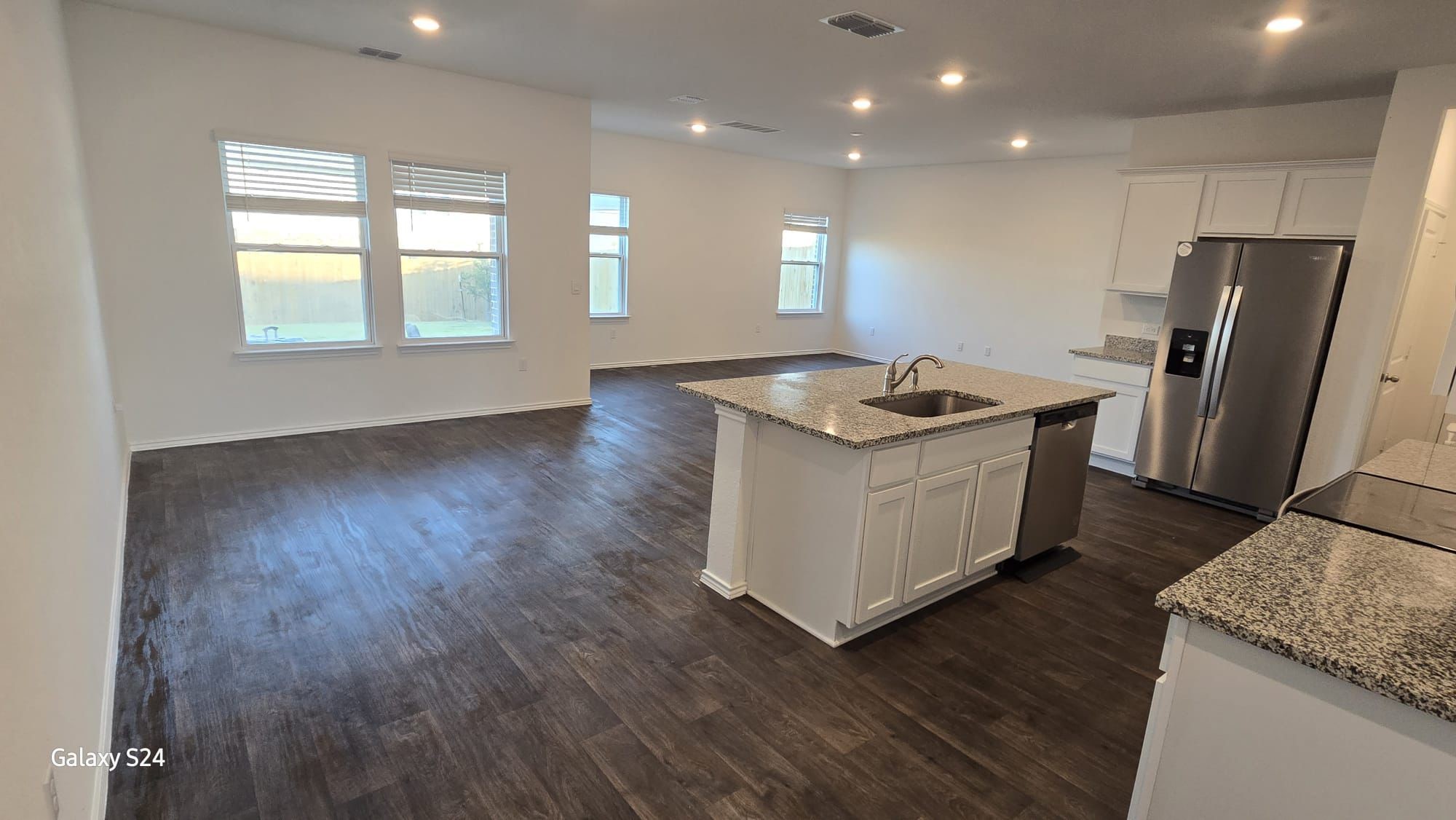 14821 Perlino Way, Unit A Manor, TX 78653 - Photo 3 of 20 a kitchen with kitchen island granite countertop a sink and refrigerator