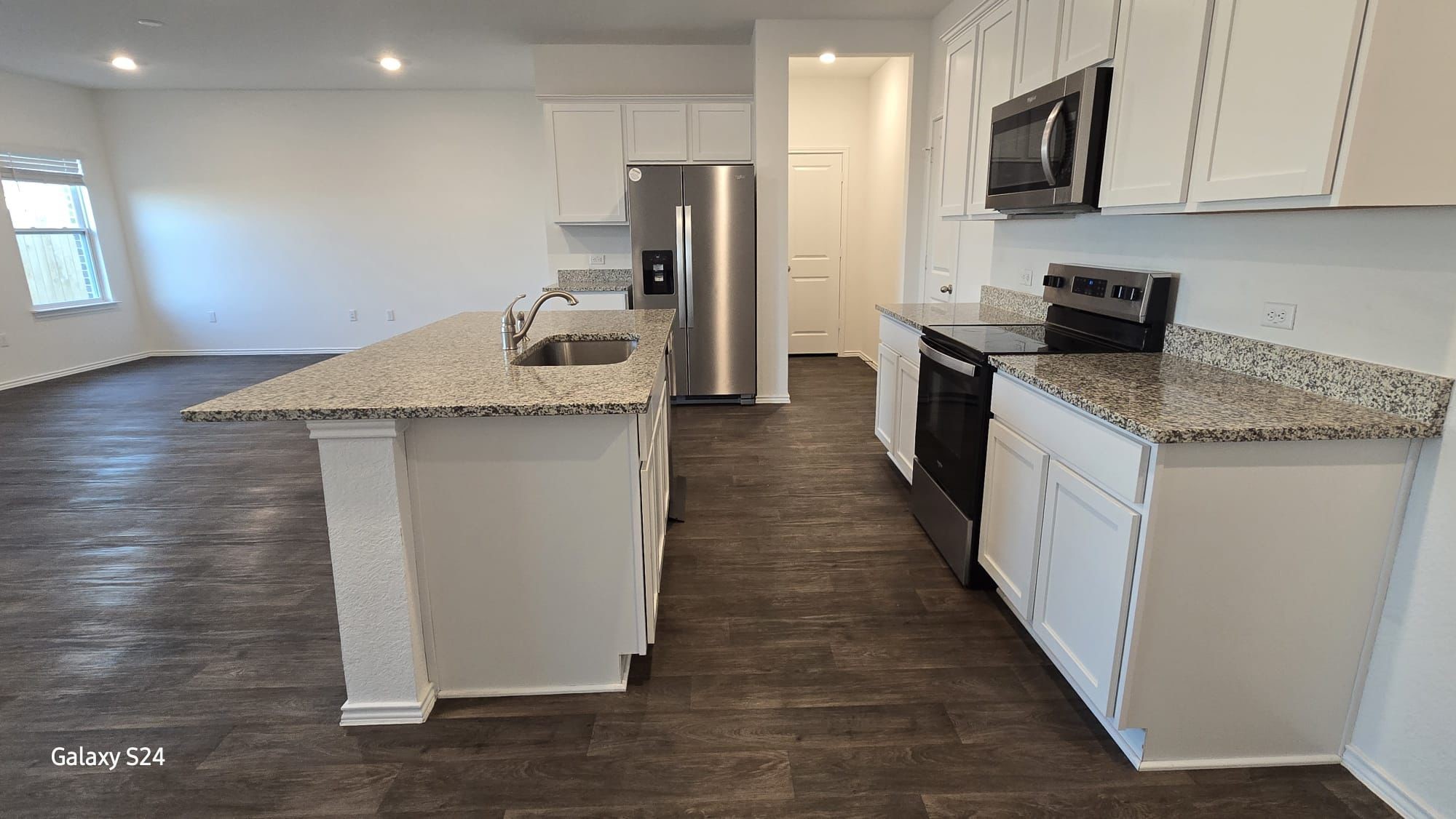 14821 Perlino Way, Unit A Manor, TX 78653 - Photo 4 of 20 a kitchen with granite countertop a sink a counter top space stainless steel appliances and cabinets