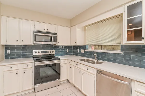 a kitchen with cabinets stainless steel appliances and a sink