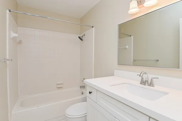 a bathroom with a granite countertop sink a toilet and shower