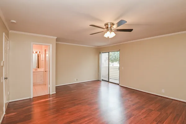a view of an empty room with window and wooden floor