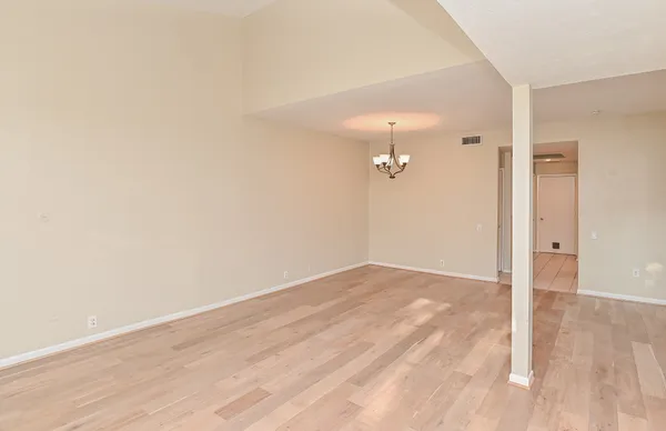 an empty room with wooden floor and cabinet