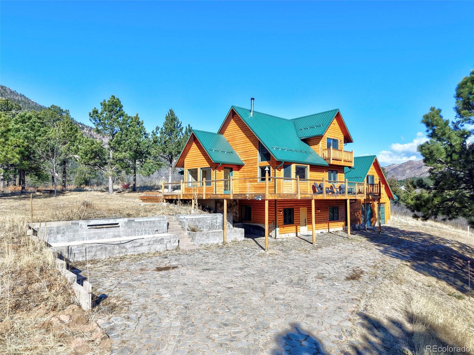 7415 Highway 24 Cascade, CO 80809 - Photo 7 of 45 a view of a large house with large trees and wooden fence