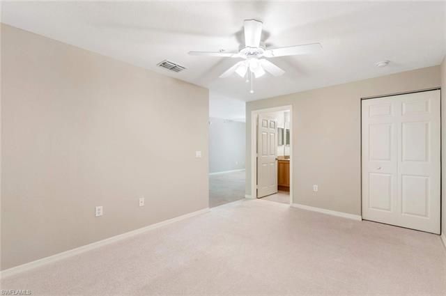 en empty room with an entryway and chandelier fan