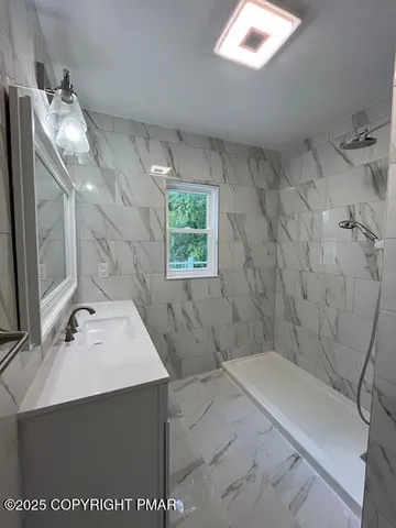 a bathroom with a sink a toilet and shower