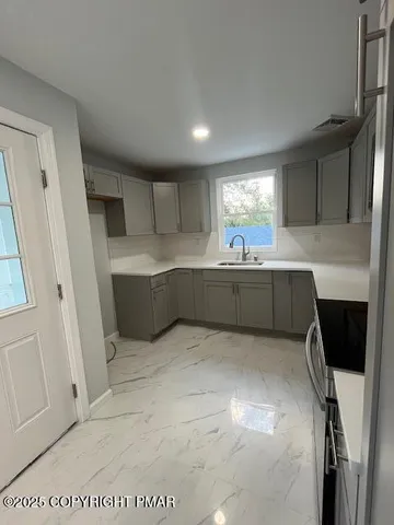 a kitchen with stainless steel appliances granite countertop a sink refrigerator and microwave