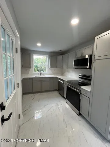 a kitchen with granite countertop a refrigerator and a stove top oven
