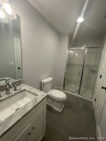 a bathroom with a granite countertop sink toilet and shower