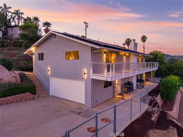 a front view of house with yard and trees in the background