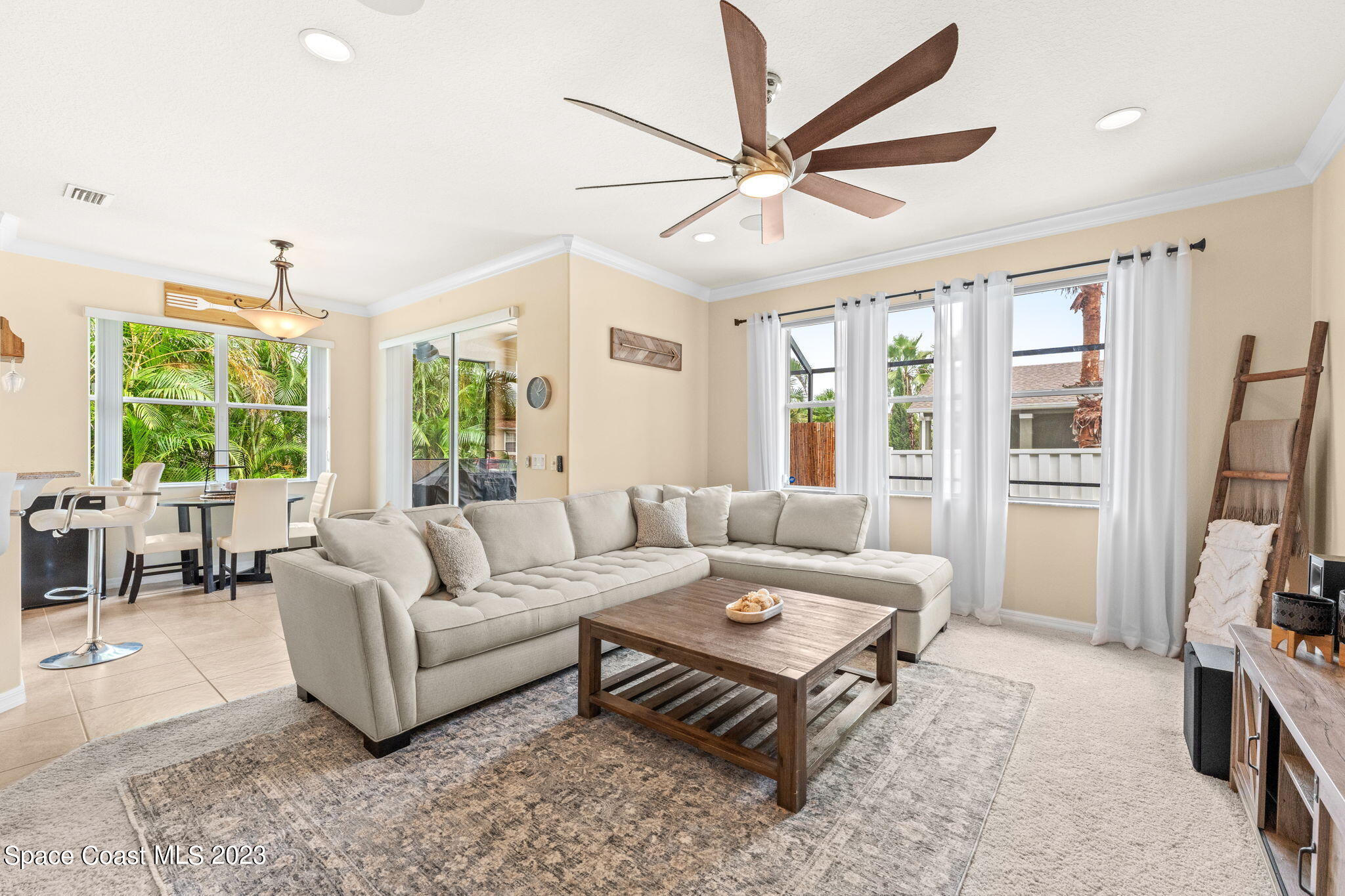 6265 Trieda Drive Melbourne, FL 32940 - Photo 3 of 26 a living room with furniture a flat screen tv and a large window