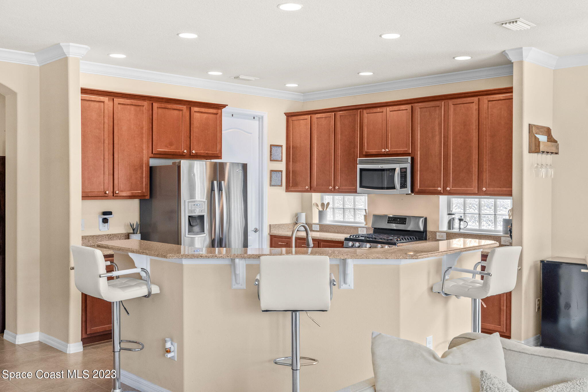 6265 Trieda Drive Melbourne, FL 32940 - Photo 4 of 26 a kitchen with stainless steel appliances granite countertop a refrigerator a stove top oven a sink and cabinets
