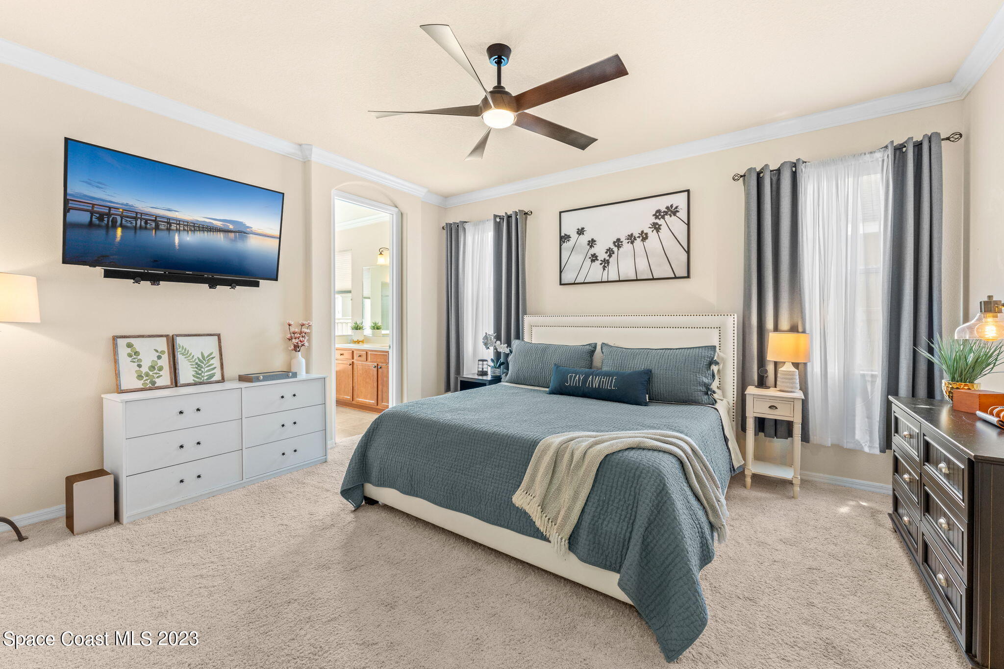 6265 Trieda Drive Melbourne, FL 32940 - Photo 9 of 26 a bedroom with a large bed and a flat screen tv