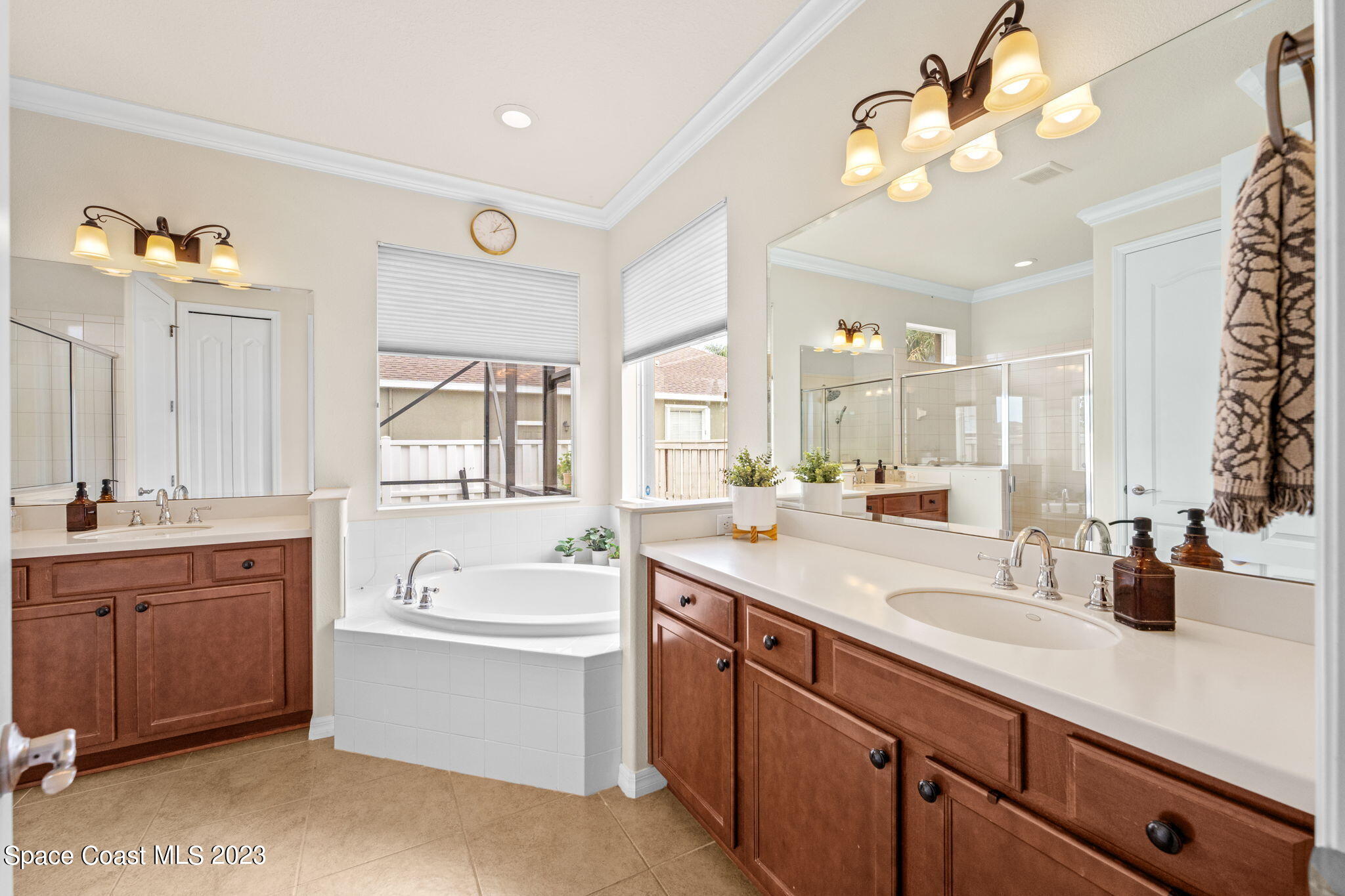 6265 Trieda Drive Melbourne, FL 32940 - Photo 10 of 26 a bathroom with a tub a sink double vanity and a mirror