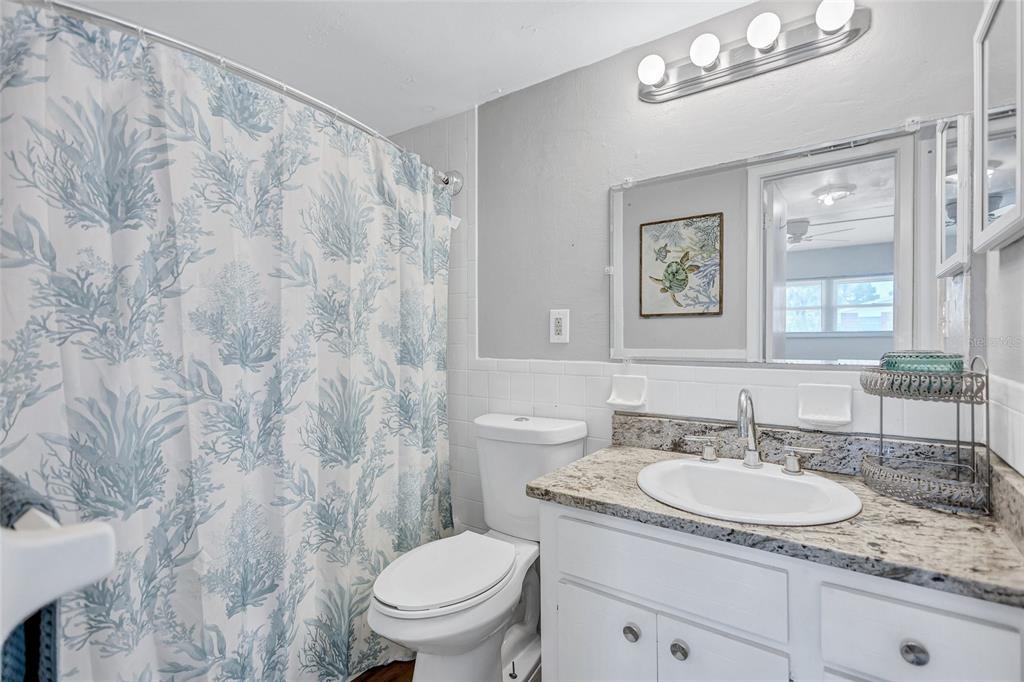 3125 36th Street North, Unit 208 St. Petersburg, FL 33713 - Photo 19 of 29 a bathroom with a granite countertop sink a toilet and a mirror