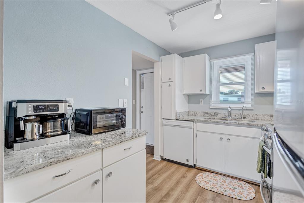 3125 36th Street North, Unit 208 St. Petersburg, FL 33713 - Photo 3 of 29 a kitchen with stainless steel appliances granite countertop a sink and stove top oven