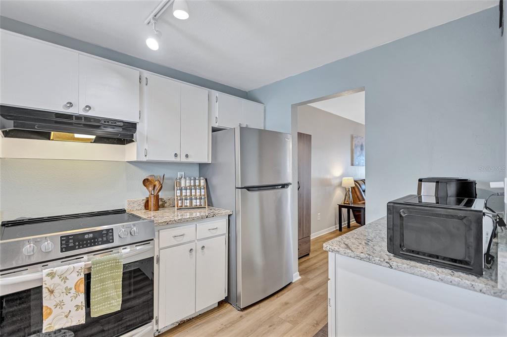 3125 36th Street North, Unit 208 St. Petersburg, FL 33713 - Photo 4 of 29 a kitchen with stainless steel appliances granite countertop a refrigerator stove and sink