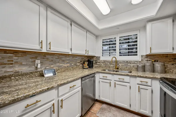 a kitchen with stainless steel appliances a sink a stove and cabinets