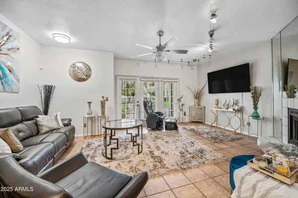 a living room with furniture a flat screen tv and a large window