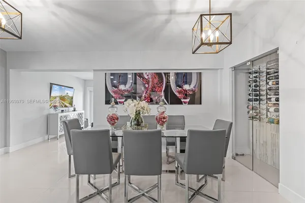 a view of a dining room with furniture a chandelier and wooden floor