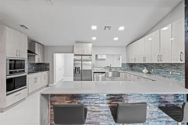 a kitchen with stainless steel appliances granite countertop a stove a sink and a refrigerator