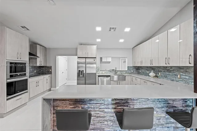 a kitchen with stainless steel appliances granite countertop a stove a sink and a refrigerator