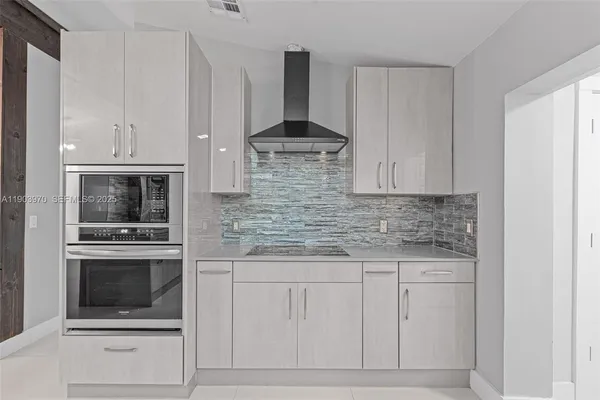 a kitchen with stainless steel appliances granite countertop a stove microwave and cabinets