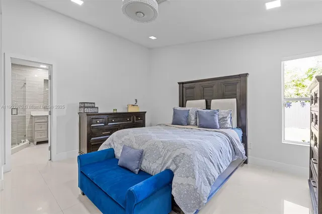 a bedroom with a bed and dresser with mirror