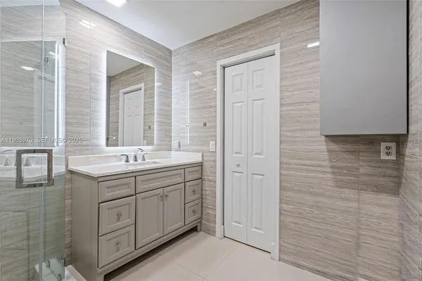 a bathroom with a double vanity sink a large mirror and a bathtub