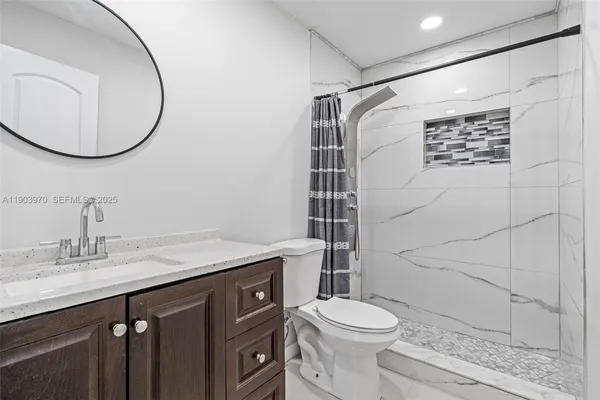 a bathroom with a sink a toilet and shower