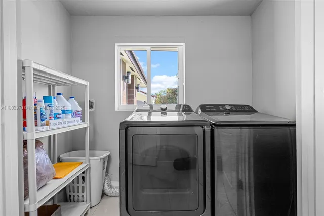 a utility room with stainless steel appliances kitchen island granite countertop a refrigerator and a stove