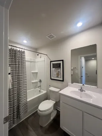 a bathroom with a toilet a sink shower and a mirror