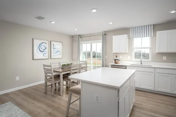 a kitchen with a stove a table and chairs