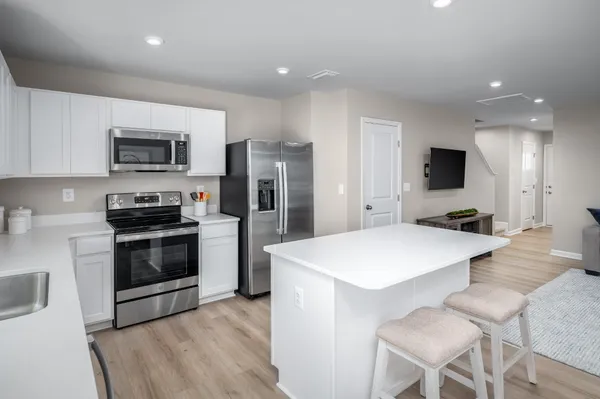 a kitchen with stainless steel appliances a stove top oven a refrigerator a sink and a stove